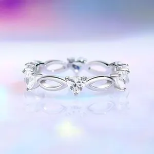 Macro shot of S925 silver ring featuring heart zircons and infinity symbols on purple background