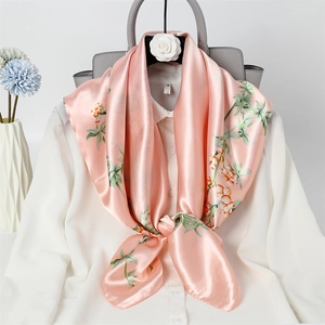 Elegant pink silk square scarf with floral pattern tied gracefully over a white shirt