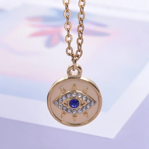 Vue macro du pendentif œil maléfique plaqué or 18k avec cristaux bleus et strass