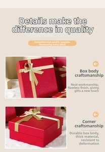Detail of red textured gift box with a sturdy corner and golden woven ribbon bow