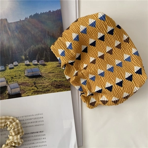 Detail of pleated fabric texture in ginger yellow with geometric diamond pattern