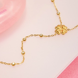 Collier Y trèfle doré avec pétales en cœur et pierres de zircon claires en vue macro