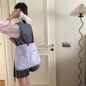 Dettaglio di una borsa a tracolla viola chiaro con coulisse e doppie tasche frontali