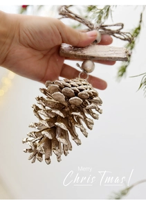 Close-up of a rustic pinecone ornament with silver glitter and a wooden hanging tag