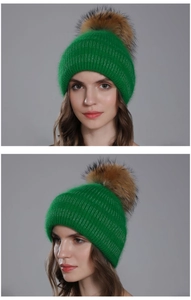 Détail d'un bonnet en tricot vert vif avec un grand pompon en fourrure marron duveteux