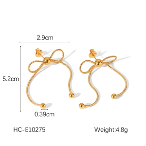 Detail of 18k gold plated stainless steel bow earrings with hanging snake chain drops