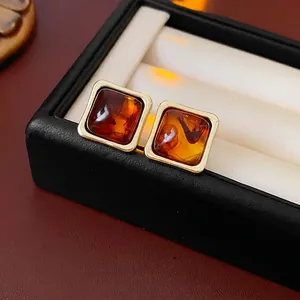 Retro square resin earrings with amber texture and gold frame in a black jewelry box