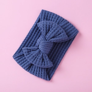 Detailed view of blue waffle knit baby headband with a large decorative soft bow