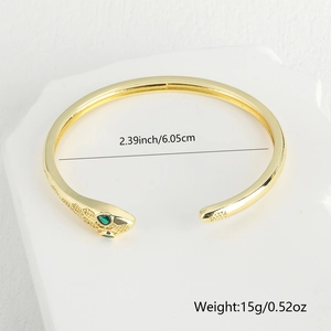 Detail of gold snake bracelet with green zircon eyes and dimension labels 6.05cm
