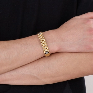 Detail of gold titanium steel watch-style link bracelet worn on male wrist