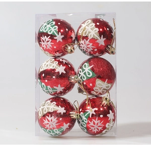 Detail showing a set of six red Christmas balls with hand-painted glitter patterns in a box