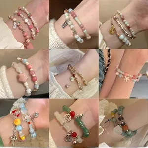 Macro shot of nine varied handmade beaded bracelets with charms and colorful pearls