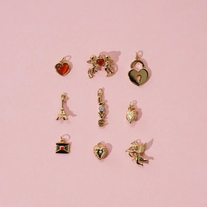 Close-up of gold-plated titanium steel pendants with red heart charms for jewelry making