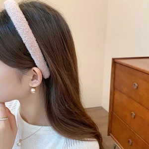 Detail of pink plush fabric headband and pearl jewelry set on a female model