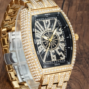 Luxury gold iced-out men's tonneau watch with compass dial on dark wood background