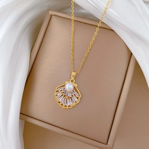 Macro shot of gold shell pendant featuring a central pearl and baguette-cut crystals