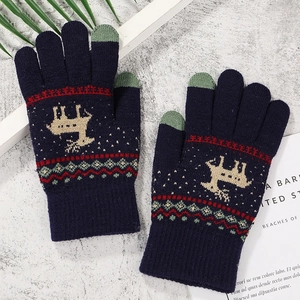 Detail of navy knit gloves with reindeer pattern and green touchscreen fingertips