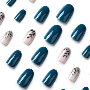 Blue and pink press-on nails with black leaf patterns and silver foil on white background