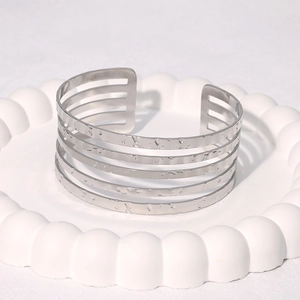 Polished silver stainless steel wide cuff bracelet with a hammered texture and open design