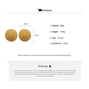 Detailed view of 2x2cm gold ball earrings with frosted texture and silver needles