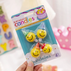 Set of 4 yellow smiley bear birthday candles with party hats made of natural wax