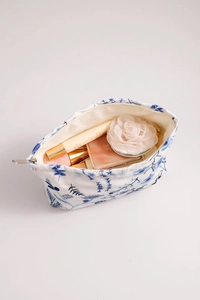 Détail de la trousse de maquillage en coton et lin blanc avec broderie florale bleue
