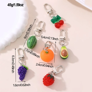 Flat lay of colorful fruit charms including cherry and avocado with weight and size specs