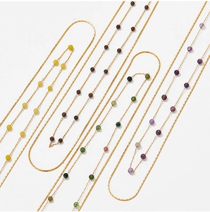 Macro shot of stainless steel snake chain necklaces featuring colorful natural stone beads