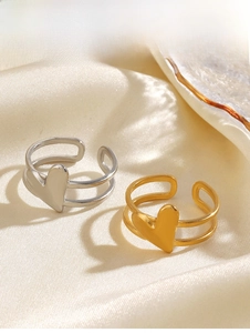Detail of gold and silver heart rings on silk fabric showing the parallel band design