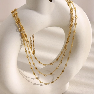 Elegant 18K gold-plated multilayer stainless steel chain necklace on ceramic display