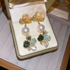 Gros plan de boucles d'oreilles vintage en perles et fleurs dans une boîte en velours
