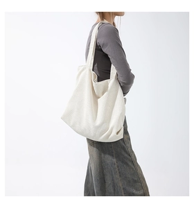 Detail view of cream-colored corduroy tote bag showing soft ribbed texture and strap
