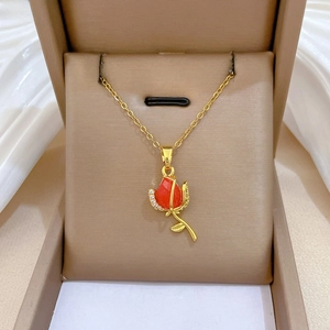 Close-up of a luxury red rose pendant necklace with diamonds on a gold chain