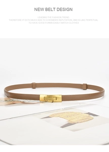 Brown leather thin belt with gold buckle coiled on a magazine with sharp product details