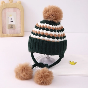 Detalle de gorro de punto para niños con patrones de rayas y suaves pompones de invierno