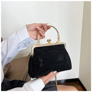 Close-up of black sequined evening bag with a vintage gold handle and rhinestone details