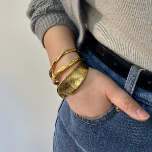 Minimalist irregular 18K gold-plated stainless steel bangles set worn by a fashion model