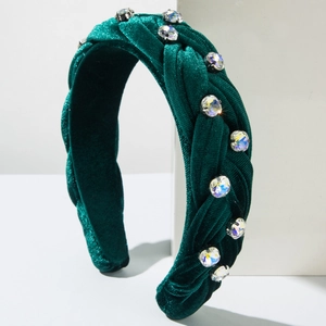 Detail of dark green velvet braided headband with sparkling large rhinestones decoration