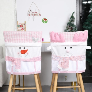 Pink Christmas chair covers with snowman and reindeer plush designs for dining room decor