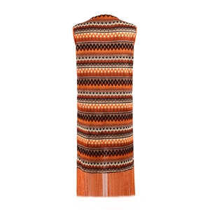 Détail du gilet sans manches bohème avec motifs géométriques orange et longues franges