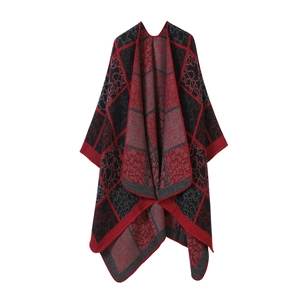 Détail d'un châle en maille double face à carreaux rouge-noir et motifs floraux sur blanc