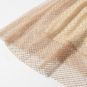 Detailed close-up of apricot mesh fabric featuring sparkling sequins and fine rhinestones