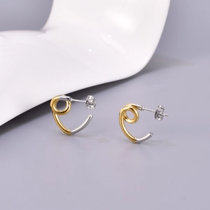 Gros plan de boucles d'oreilles spirales en acier inoxydable bicolore or et argent