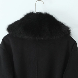 Detail of premium black faux fur collar on long wool coat showing soft fluffy texture