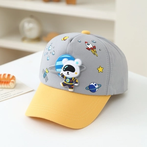 Detailed close-up of astronaut bear patch and space themed patterns on kids baseball cap