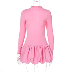 Détail d'une robe rose à manches longues avec haut en tricot côtelé et jupe à volants