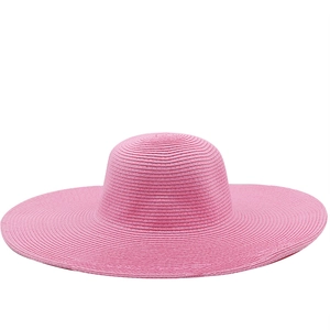 Close-up of pink wide brim straw hat showing detailed woven texture and round top design