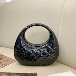Glossy black quilted clutch bag with integrated oval top handle and shiny lacquer finish