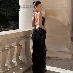 Detailed back view of a black lace backless maxi dress with delicate ruffled hem and slim fit