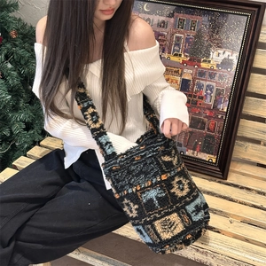 Close-up of plush geometric bucket bag featuring deep blue, orange, and beige patterns